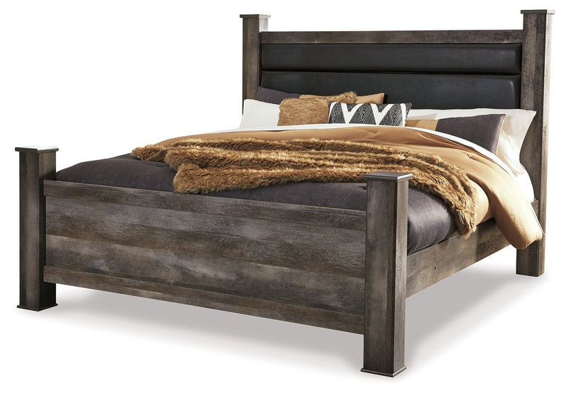 Gray upholstered poster bed with tall headboard and footboard, shown with bedding
