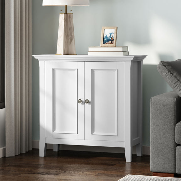 White low storage cabinet with two paneled doors and round metal knobs