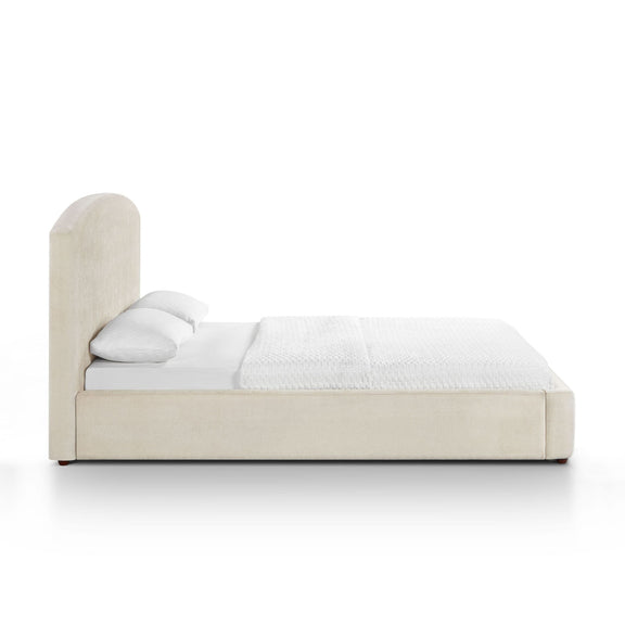 Upholstered bed with tall headboard, light brown frame, white fitted sheet and blanket