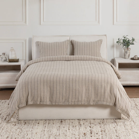 Natural striped duvet set with pillow shams and solid pillows on bed