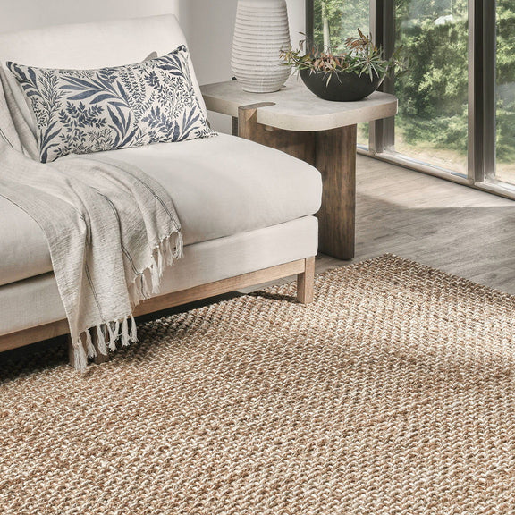Natural jute area rug with dense open-weave texture, laid flat on the floor