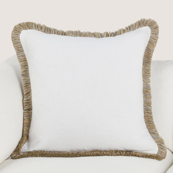 Ivory pillow on sofa with tan fringed edge close-up