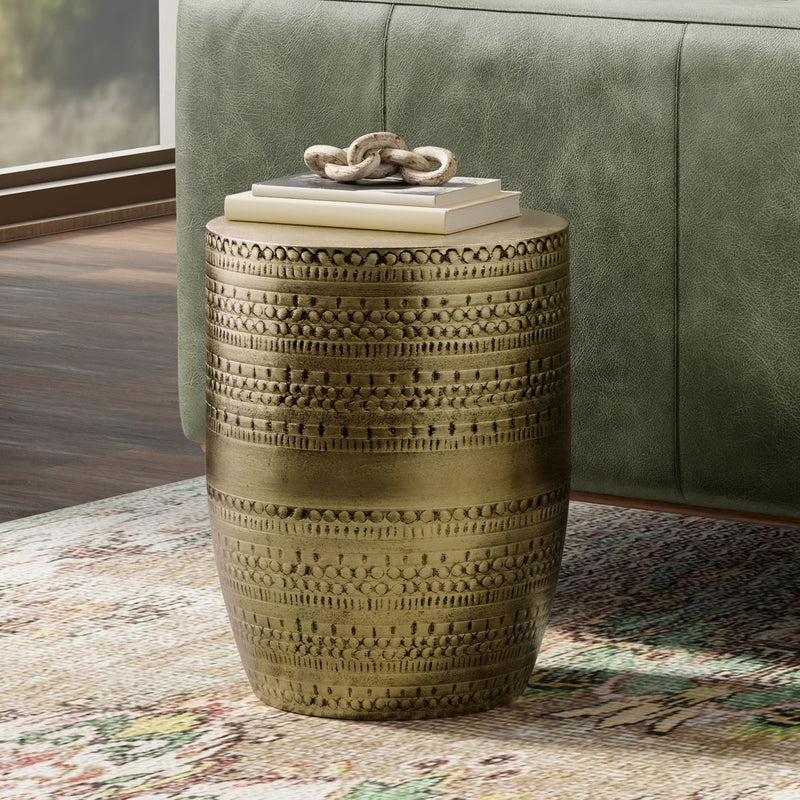 Metal drum accent table in gold finish with embossed texture and rope-style decor on top