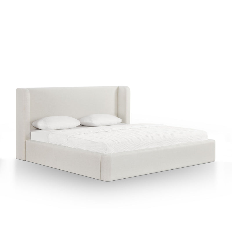 White upholstered bed frame with tall headboard and white pillows on bedding