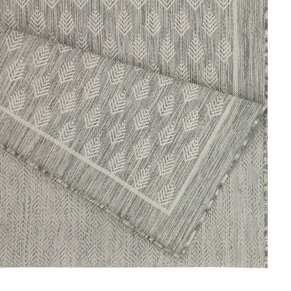 Light gray area rug with repeating diamond pattern and fringed trim edge