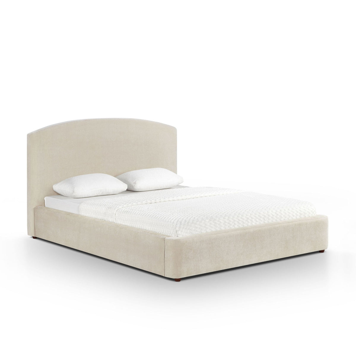 Light brown upholstered bed with rounded headboard, white pillows and textured blanket