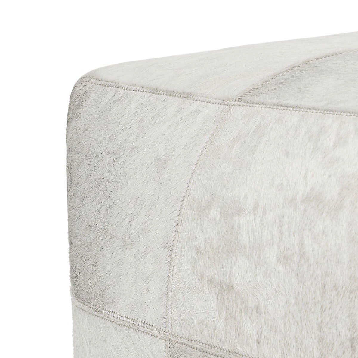 Ivory hide pouf corner detail with visible seam stitching along the side