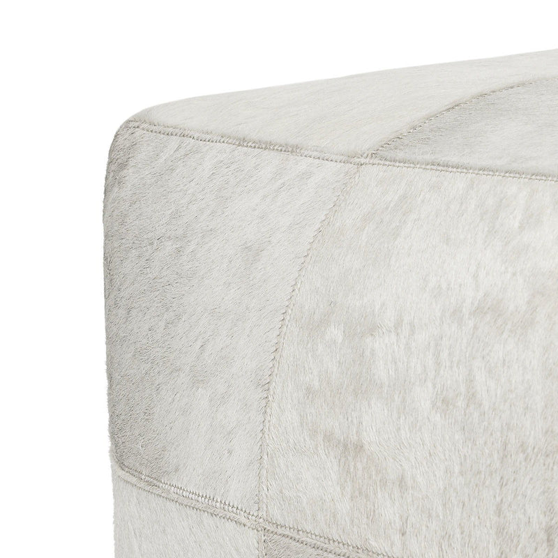 Ivory hide pouf corner detail with visible seam stitching along the side
