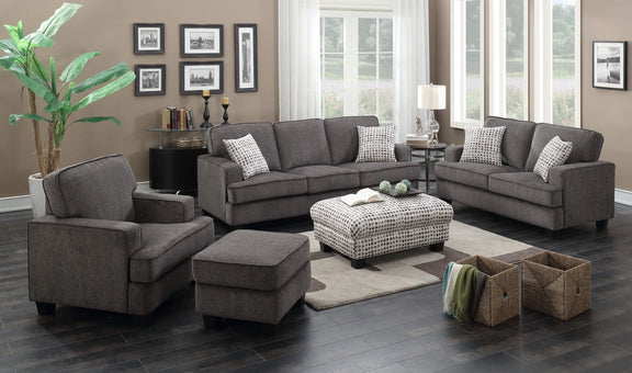Ottoman with dark ink-dot fabric cover in front of grey sofa set