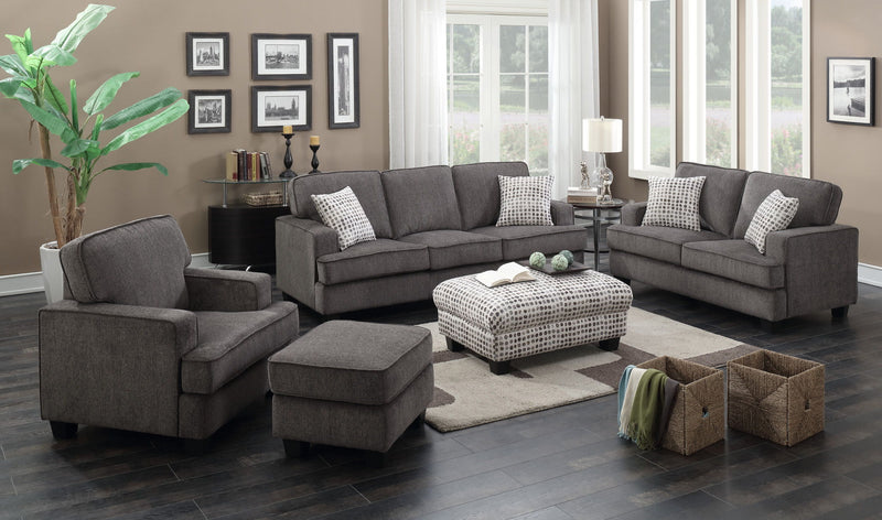 Ottoman with dark ink-dot fabric cover in front of grey sofa set