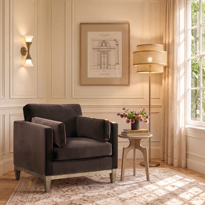Dark gray upholstered armchair with padded arms, cushioned seat, and slim legs.