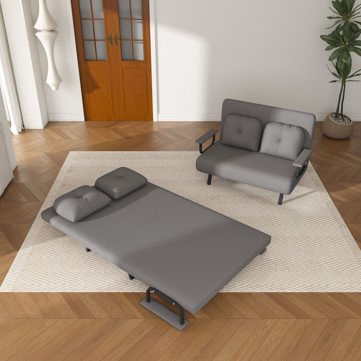 Convertible sofa bed, dark gray fabric opened into a flat bed with cushions.