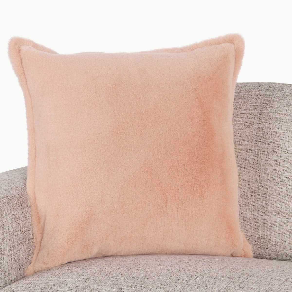 Peach plush throw pillow with piped edges and rounded corners