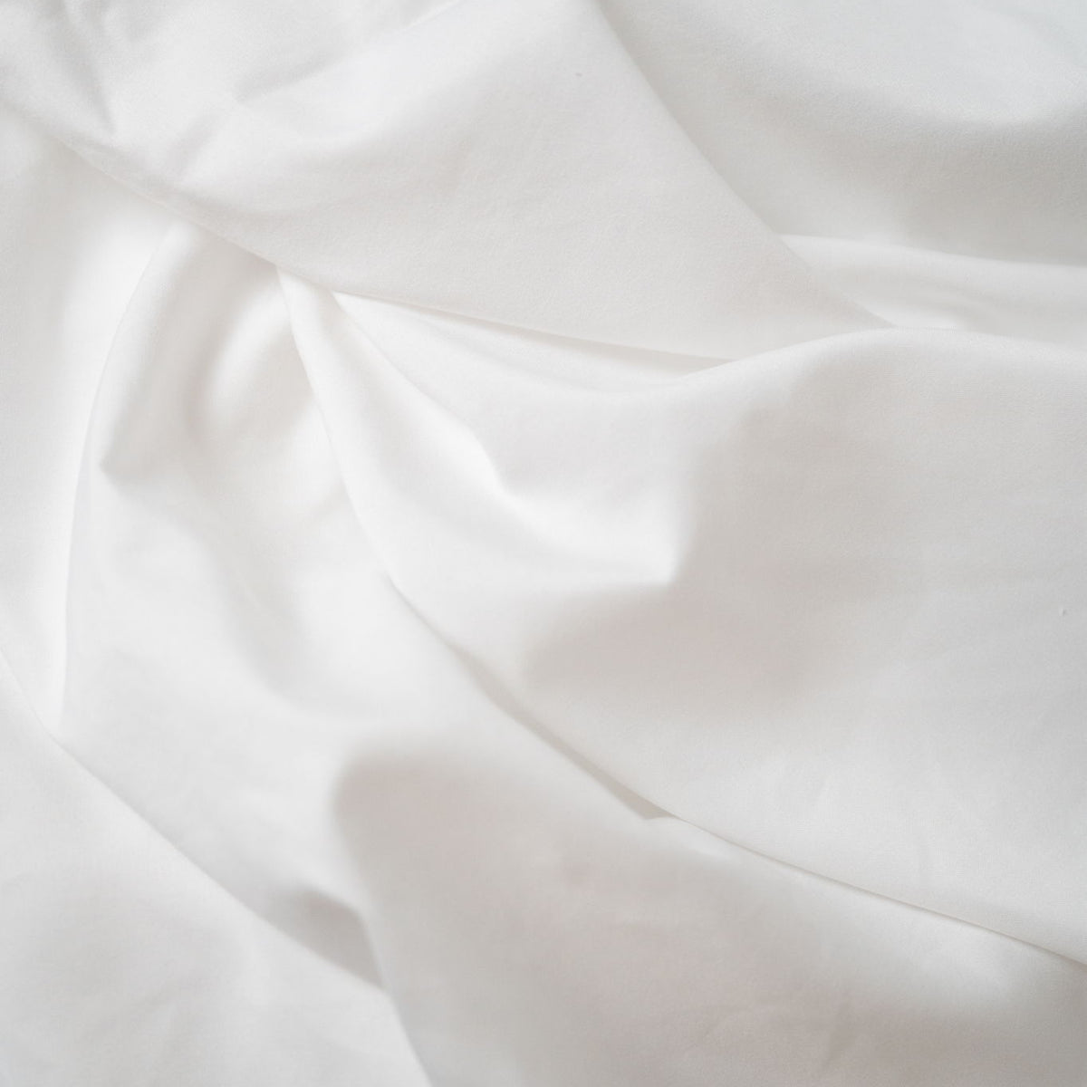 Brushed hypoallergenic sheet fabric close-up in white, soft wrinkle texture