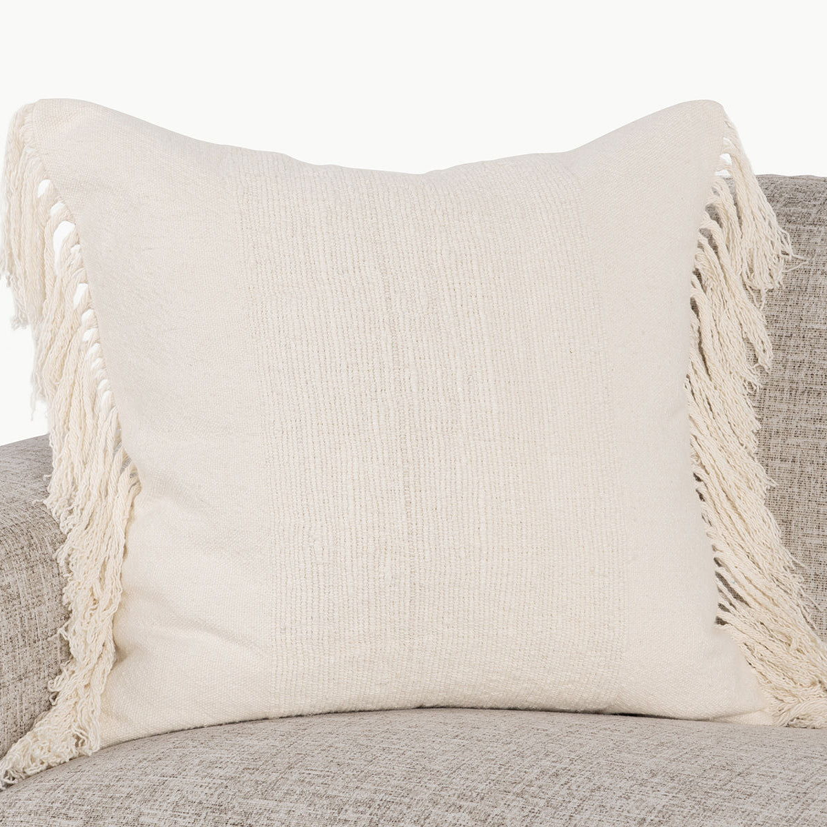 Ivory square pillow with woven texture and corner tassel fringe detail