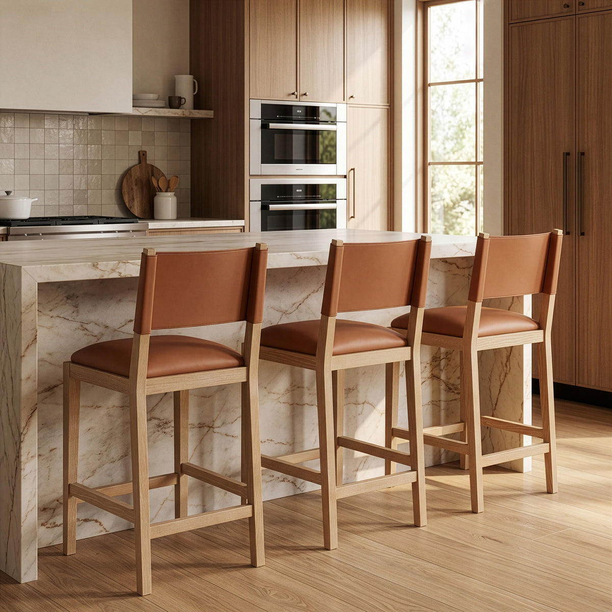 Set of light brown vegan leather counter stools with cushioned seats and wood legs