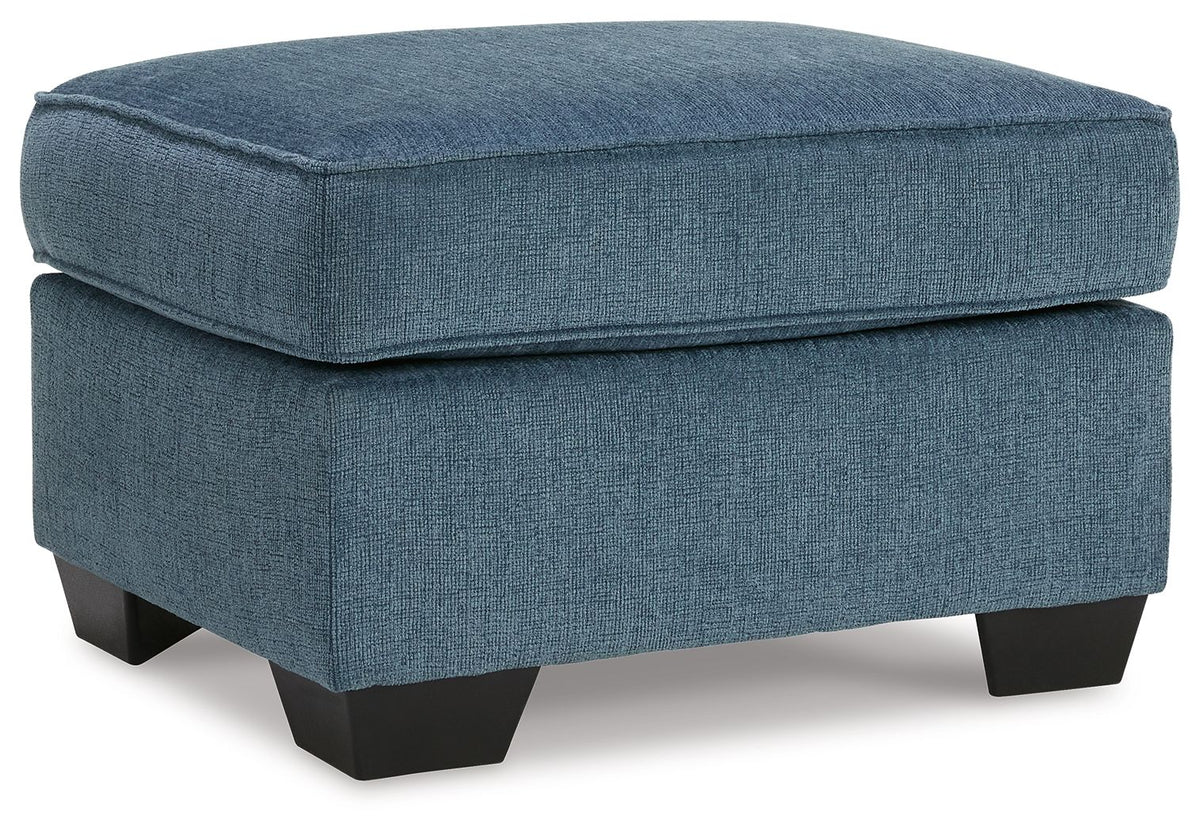 Blue upholstered ottoman with cushioned top and dark block legs
