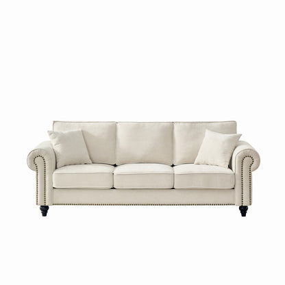 Beige 3-seat sofa with tufted back cushions, rolled arms, and nailhead trim