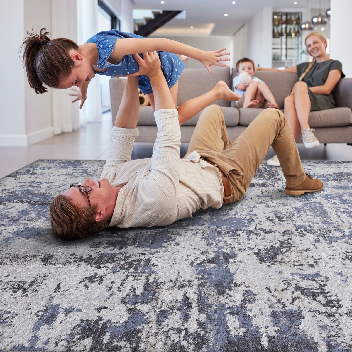 Abstract area rug with blue-gray distressed motif and beige speckles, rectangular