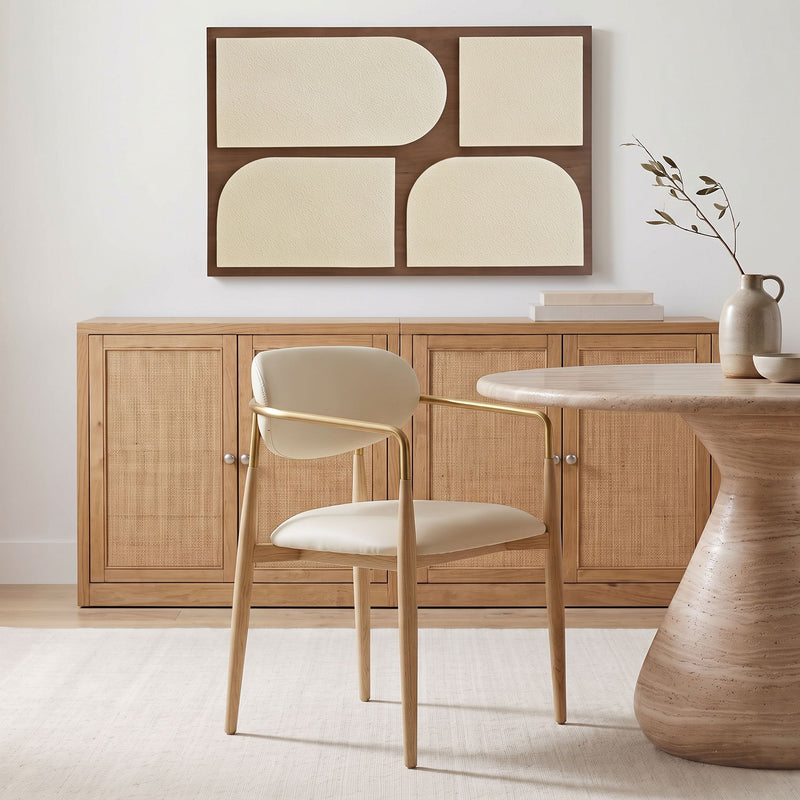 Vegan leather dining arm chair with light gray seat, curved gold-tone armrests, wood legs