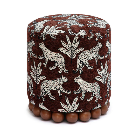 Dark brown animal-print ottoman with dark wood ball base; round cushioned top.