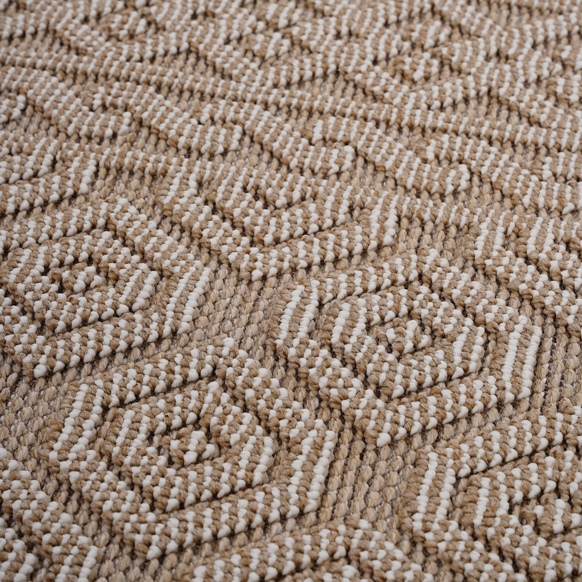 Geometric indoor/outdoor area rug, light brown and white pile texture close-up