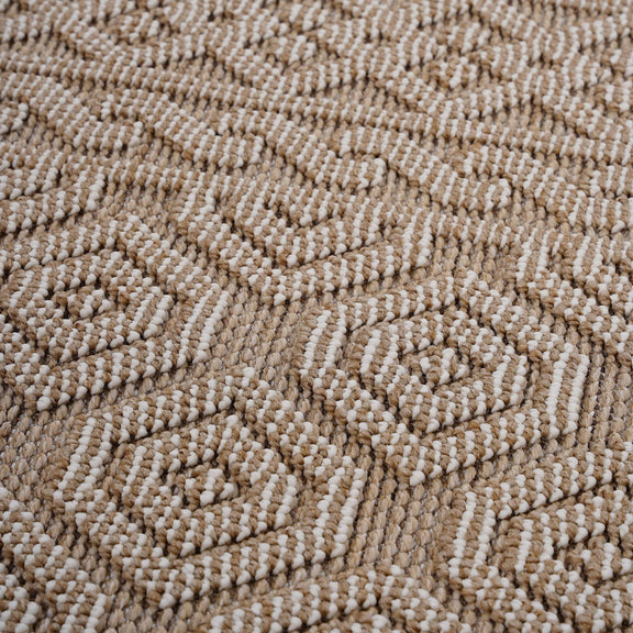 Geometric indoor/outdoor area rug, light brown and white pile texture close-up
