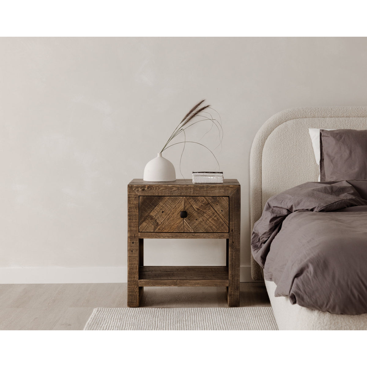 Oatmeal upholstered queen bed headboard corner with layered bedding