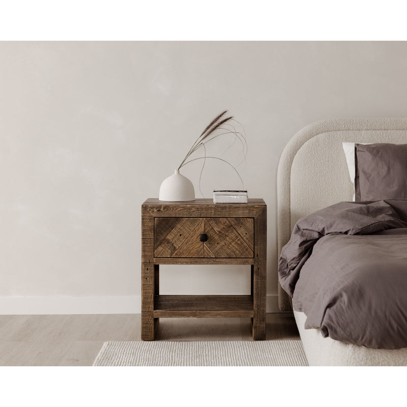 Oatmeal upholstered queen bed headboard corner with layered bedding