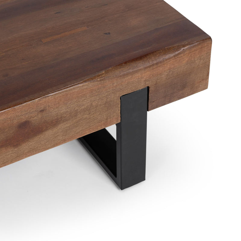 Close-up of reclaimed brown wood tabletop edge and black metal leg