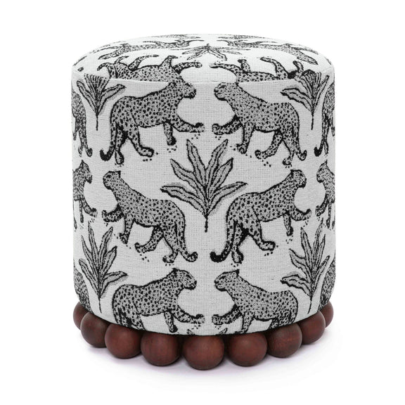 Gray fabric ottoman with black-and-white animal pattern and dark wood ball base.