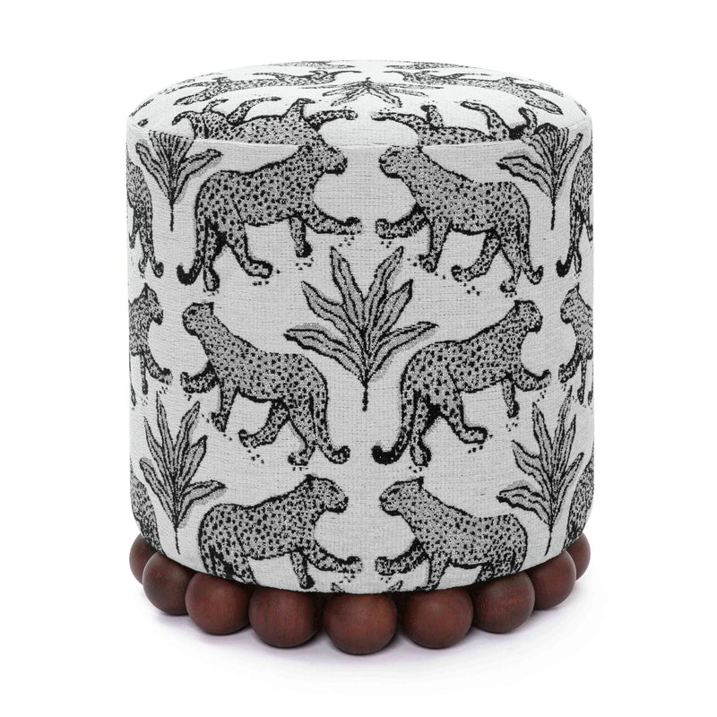 Gray fabric ottoman with black-and-white animal pattern and dark wood ball base.