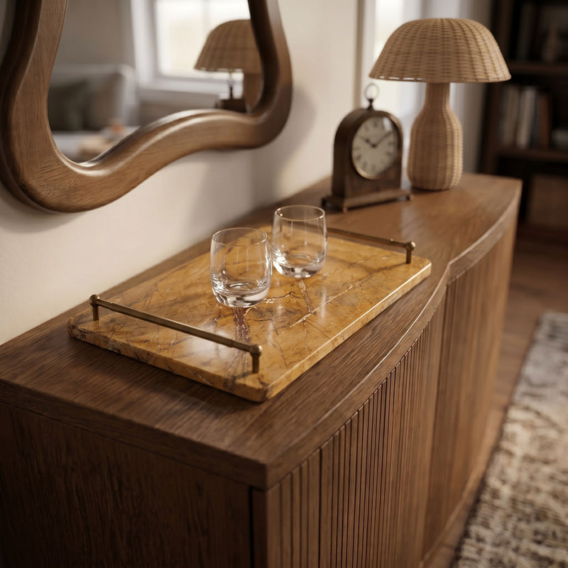 Golden beige marble serving tray with brass corner handles and two clear glasses.