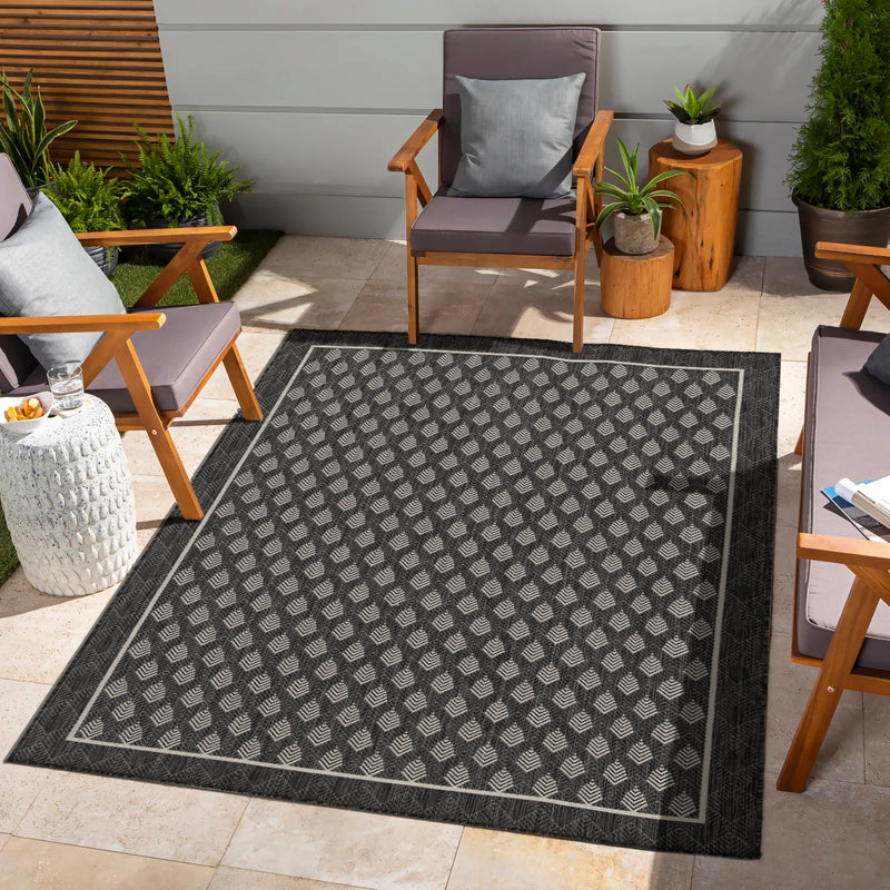 Indoor/outdoor polypropylene area rug, dark gray with repeating chevron pattern border