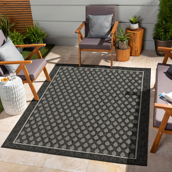 Dark gray indoor/outdoor area rug with repeating white diamond pattern and border