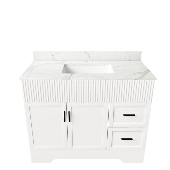 White bathroom vanity with fluted front panel, sink top, two doors and two drawers.