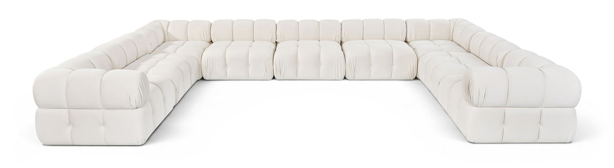 White velvet upholstered sectional sofa with tufted cushions and rounded arm sections