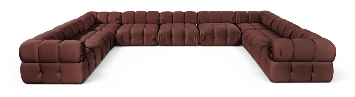 Burgundy velvet upholstered sectional sofa with tufted cushions and curved armrests