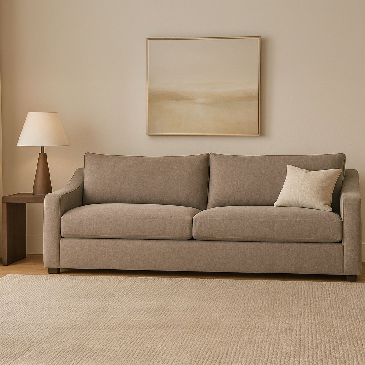 Taupe fabric sofa with two seat cushions and matching back cushions, plus cream pillow
