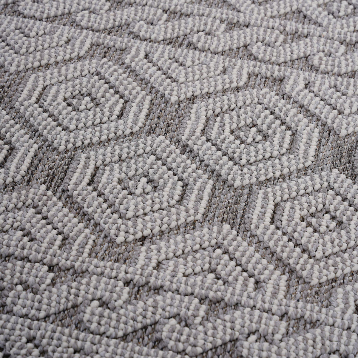 Gray-and-white geometric area rug with repeating diamond pattern in raised loop texture