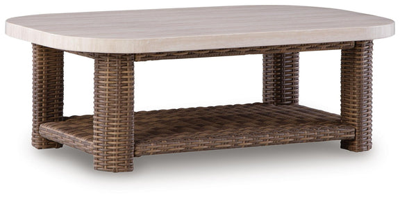 Rectangular wicker cocktail table with beige tabletop and brown woven lower shelf