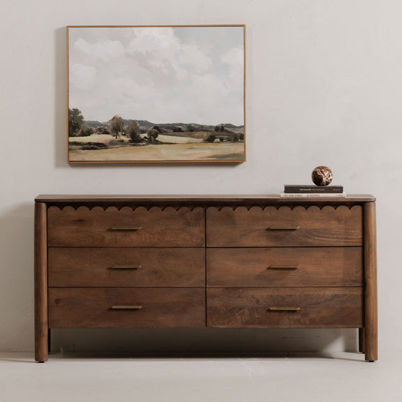 Vintage brown dresser with four drawers, scalloped trim, and gold bar pulls