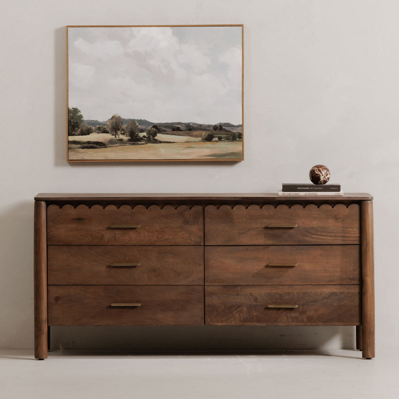 Vintage brown dresser with four drawers, scalloped trim, and gold bar pulls