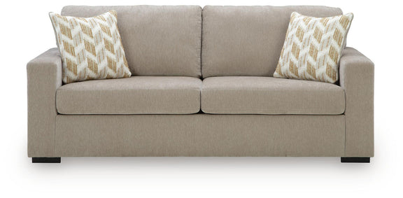 Beige fabric sofa with tufted back, two seat cushions, and patterned accent pillows