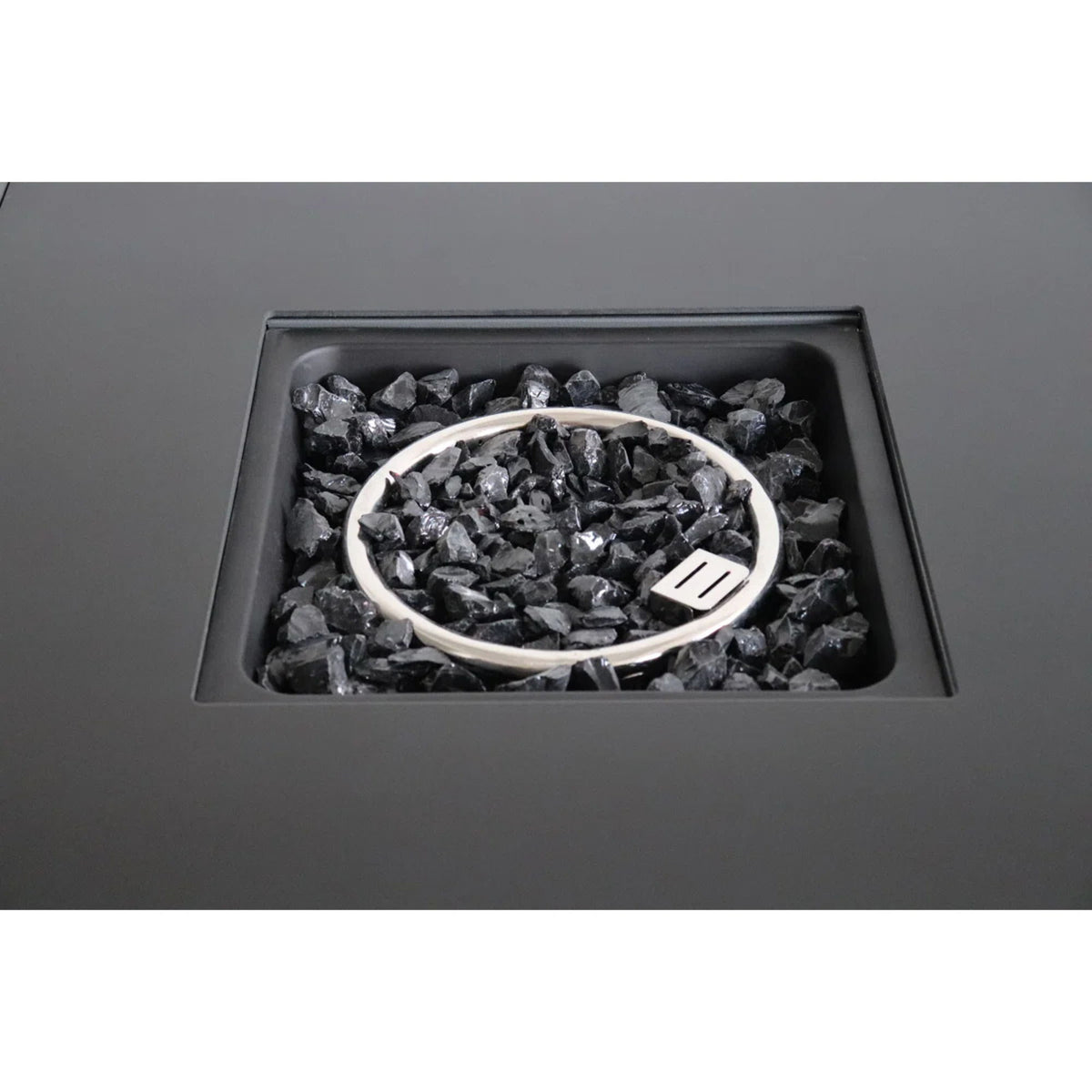Open fire pit table showing black lava rocks in the fire bowl