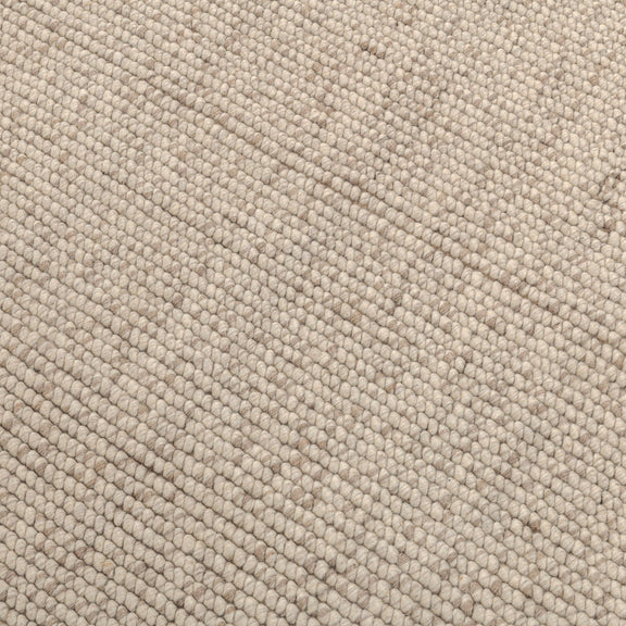 Natural woven rug close-up with textured speckle pattern