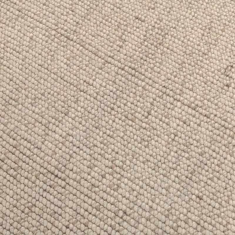 Natural woven rug close-up with textured speckle pattern
