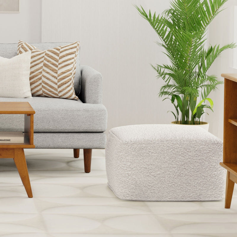Ivory square pouf with textured upholstery and softly rounded edges