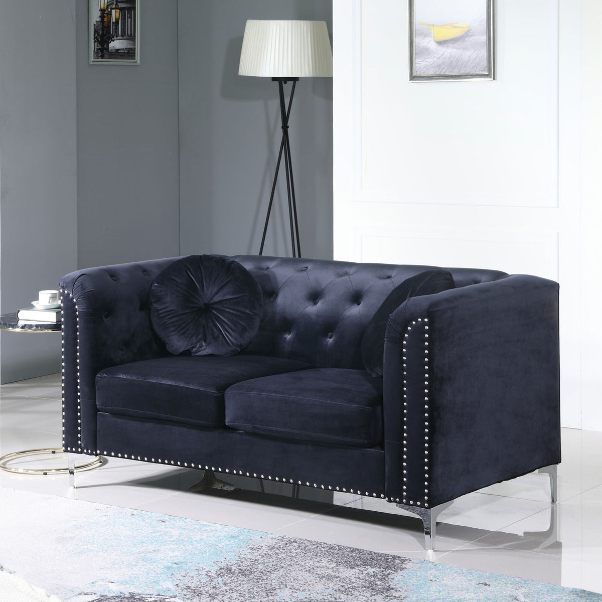 Dark upholstered loveseat with sloped arms, tufted back, and nailhead trim
