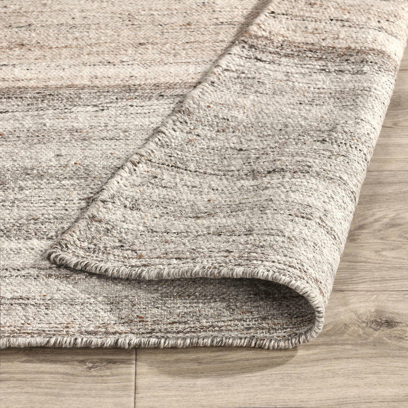 Sand and gray rug corner closeup with short fringe and flatwoven low-pile texture